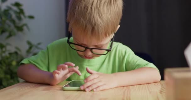 Προσχολαστικό Αγόρι Που Φοράει Γυαλιά Απολαμβάνει Παίζει Παιχνίδια Smartphone Ανησυχώντας — Αρχείο Βίντεο
