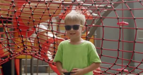 Swagging Preschooler Boy Wearing Bright Sunglasses Shows Remote Controller Toy — Wideo stockowe