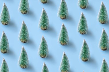 Yeşil Noel ağacı desenleri mavi pastel arka planda minimal yassı Yeni yıl bayramı kutlamaları konsepti