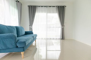 Oturma odasındaki mavi kanepe. Evin arka planı.