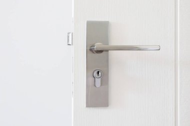 Beyaz kapısında anahtar deliği olan modern kapı kolu.