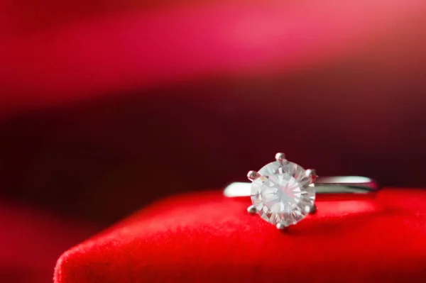 赤い生地の背景にジュエリーギフトボックス付きダイヤモンドリング — ストック写真