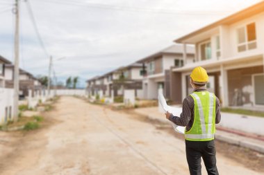 İnşaat alanındaki koruma miğferi ve bina planlarında uzman mühendis.