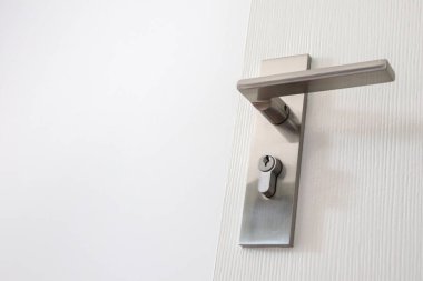 Beyaz kapısında anahtar deliği olan modern kapı kolu.