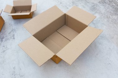 Beton zeminde boş kahverengi karton kutuyu aç
