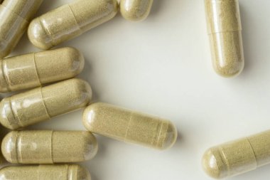 Beyaz arka planda bitkisel ilaç kapsülleri