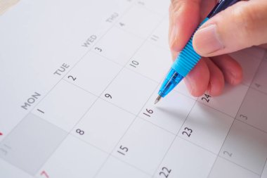 Takvim tarihi iş planlama randevusu konsepti üzerine kalem yazan kadın eli
