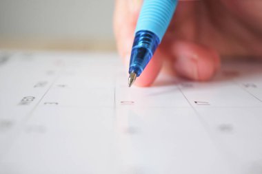 Takvim tarihi iş planlama randevusu konsepti üzerine kalem yazan kadın eli