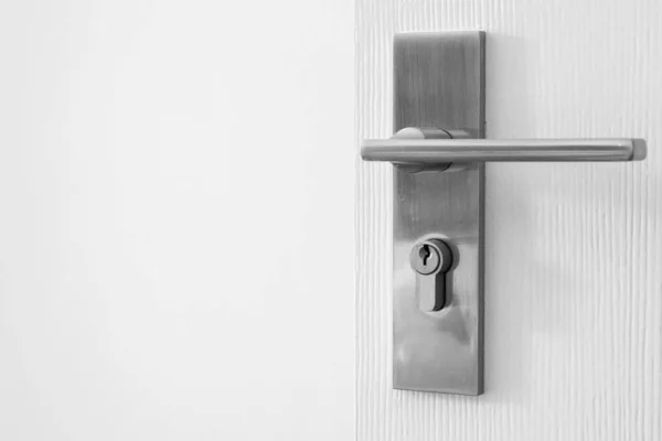 Modern door handle with keyhole on white door