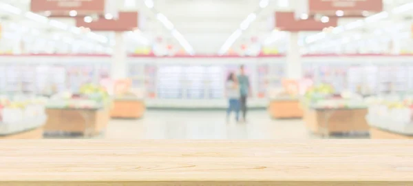 Wood table top with supermarket grocery store blurred defocused background with bokeh light for product display