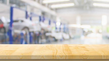 Boş ahşap masa üstü ve araba servisi merkezi oto tamir atölyesi bulanık arkaplan