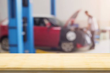 Boş ahşap masa üstü ve araba servisi merkezi oto tamir atölyesi bulanık arkaplan