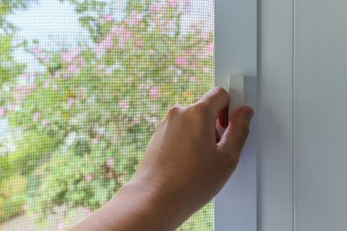 Ev penceresinde el ele tutuşan sivrisinek ağı tel ekran sapı