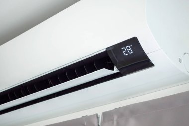 Beyaz duvar odasının arka planında klima var.