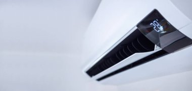 Beyaz duvar odasının arka planında klima var.