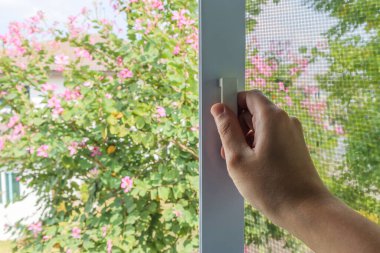 Ev penceresinde el ele tutuşan sivrisinek ağı tel ekran sapı