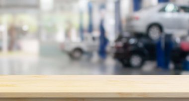 Boş ahşap masa üstü ve araba servisi merkezi oto tamir atölyesi bulanık arkaplan