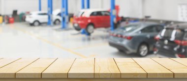 Boş ahşap masa üstü ve araba servisi merkezi oto tamir atölyesi bulanık arkaplan