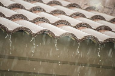 Evin çatısından yağmur yağıyor.