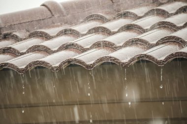 Evin çatısından yağmur yağıyor.