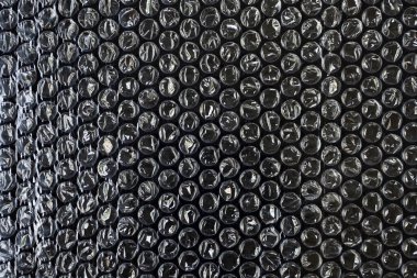 Siyah arkaplan dokusu üzerine plastik hava kabarcığı paketleme malzemesi