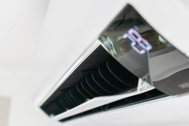 Beyaz duvar odasının arka planında klima var.