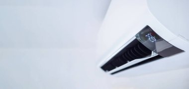 Beyaz duvar odasının arka planında klima var.