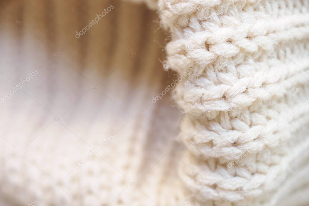 closeup beige knitted woolen fabric texture background