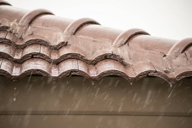 Evin çatısından yağmur yağıyor.