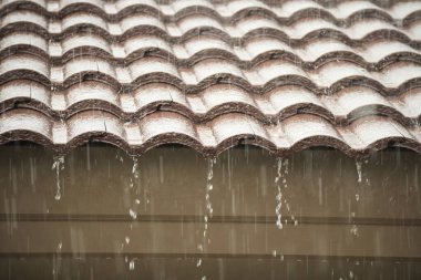 Evin çatısından yağmur yağıyor.