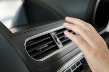 hand checking air conditioner system inside the car
