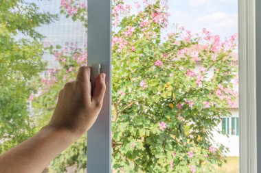 Ev penceresinde el ele tutuşan sivrisinek ağı tel ekran sapı