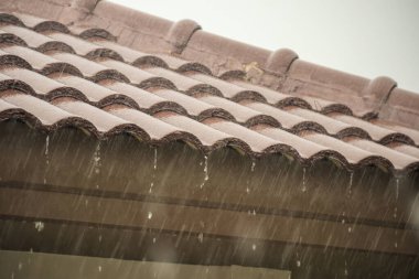 Evin çatısından yağmur yağıyor.