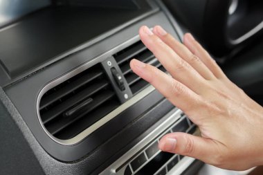 hand checking air conditioner system inside the car
