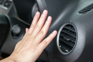 Arabanın içindeki havalandırma sistemini elle kontrol ediyorum.