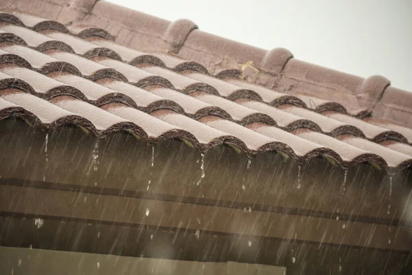 Evin çatısından yağmur yağıyor.