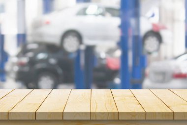 Boş ahşap masa üstü ve araba servisi merkezi oto tamir atölyesi bulanık arkaplan