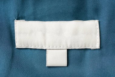 Kumaş arkaplanda beyaz kuru temizleme giysileri etiketi