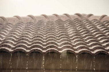 Evin çatısından yağmur yağıyor.