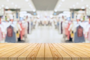 Boş ahşap masa üstü ve bulanık kıyafet butiği iç alışveriş merkezinin arka planı.