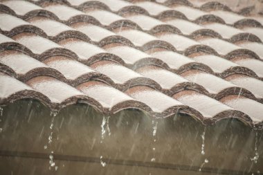 Evin çatısından yağmur yağıyor.