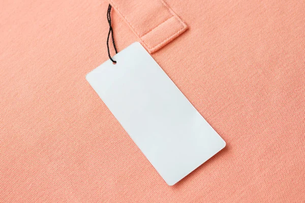 Leere Weiße Kleidung Tag Etikett Auf Rosa Stoff Textur Hintergrund — Stockfoto