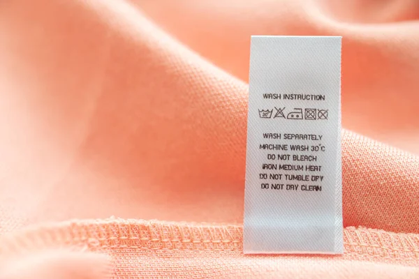 White Laundry Care Washing Instructions Clothes Label Pink Cotton Shirt — ストック写真