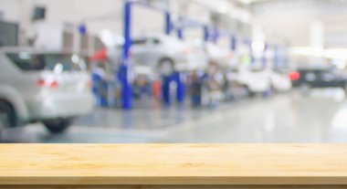 Boş ahşap masa üstü ve araba servisi merkezi oto tamir atölyesi bulanık arkaplan