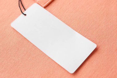 Pembe kumaş desen arka planında boş beyaz kıyafet etiketi