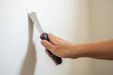 Man repairing crack white wall with spatula