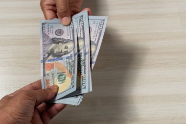 Yakından çek ve 100 dolarlık banknotları alıp satmak için odak noktasını seç. İnsanlar iş yapmak için para gönderip alıyor. Müşteri depozitoyu banka çalışanına getirir..