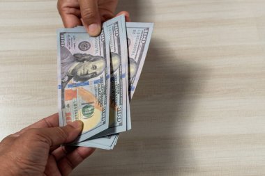 Yakından çek ve 100 dolarlık banknotları alıp satmak için odak noktasını seç. İnsanlar iş yapmak için para gönderip alıyor. Müşteri depozitoyu banka çalışanına getirir..
