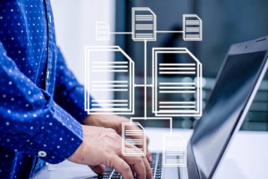 Evdeki bir odada, beyaz bir masanın üzerinde duran ve bir veritabanı ve defter bilgisayarı için yazı yazan adamlar. İş adamı internette çalışmak için bir dizüstü bilgisayar kullanır. İnsanlar geceleri evde çalışıyor..