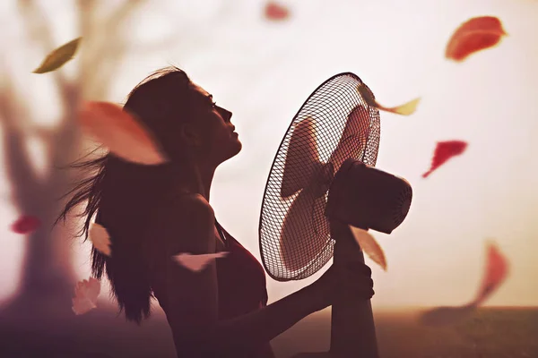 Surrealistyczna Jesień Liśćmi Poruszonymi Przez Wentylator Trzymany Przez Młodą Kobietę — Zdjęcie stockowe